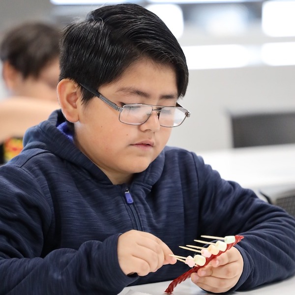 Boy works on a coding project using marshmallows