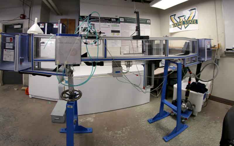 a flume rig with blue mental stands and clear glass panels with rubber tubes