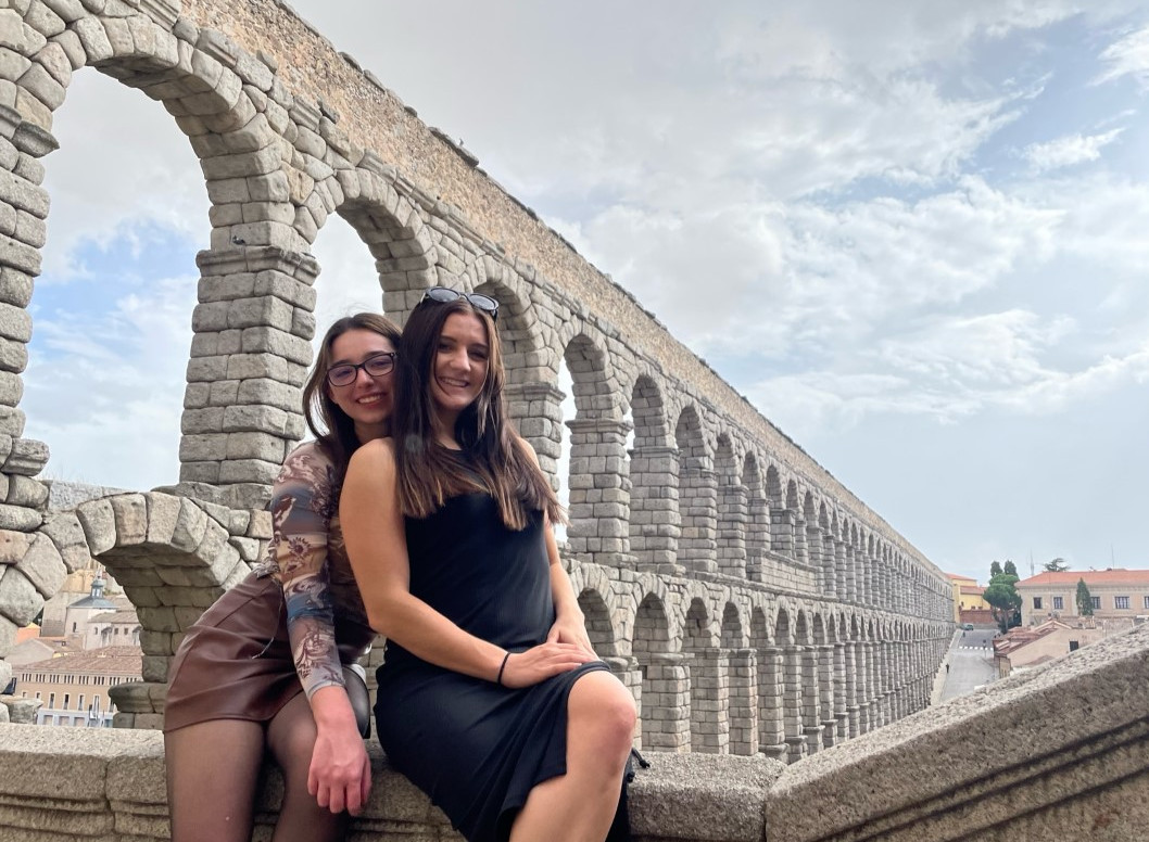 Two students pose in front of structure abroad
